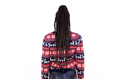 Photo for African American woman wearing Christmas sweater against white wall standing backwards looking away with arms on body. - Royalty Free Image