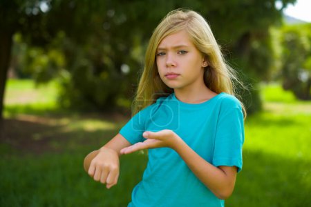 Photo for Portrait of beautiful caucasian little kid girl wearing blue t-shirt standing outdoor in the park - Royalty Free Image