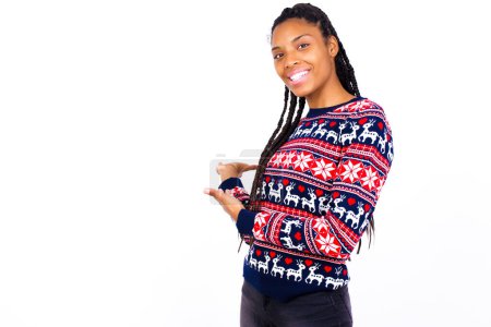 Téléchargez les photos : Femme afro-américaine portant un pull de Noël contre un mur blanc Invitant à entrer souriant naturel avec les mains ouvertes. Signe de bienvenue. - en image libre de droit
