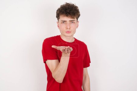 Photo for Handsome young man over white background looking at the camera blowing a kiss with hand on air being lovely and sexy. Love expression. - Royalty Free Image