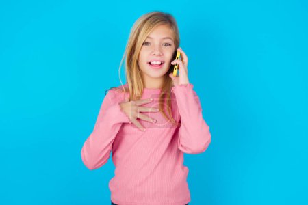 Photo for Smiling teen girl talks via cellphone, enjoys pleasant great conversation. People, technology, communication concept - Royalty Free Image