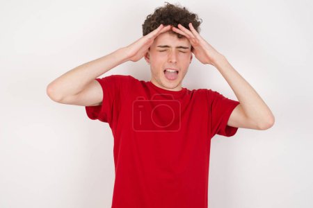 Photo for Shocked panic handsome young man over white background holding hands on head and screaming in despair and frustration. - Royalty Free Image