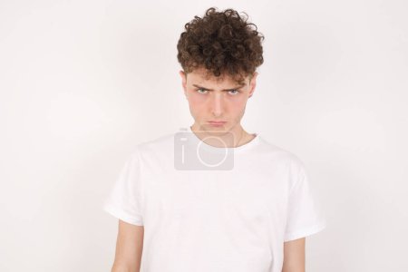 Photo for Offended dissatisfied handsome young man over white background with moody displeased expression at camera being disappointed by something - Royalty Free Image