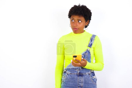Foto de Mujer joven sostiene teléfono móvil utiliza Internet de alta velocidad y las redes sociales tiene comunicación en línea. Concepto de tecnologías modernas - Imagen libre de derechos