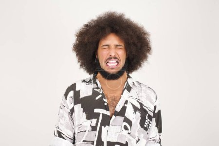 Téléchargez les photos : Portrait de beau jeune homme de race mixte expressif aux cheveux bouclés isolé sur blanc faisant grimace souffrant de douleur - en image libre de droit