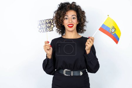 Photo for Young beautiful woman with curly hair wearing black dress, Ecuador flag and a Happy new year 2024 banner - Royalty Free Image
