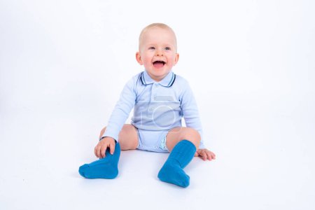 Téléchargez les photos : Portrair de mignon petit garçon enfant portant singulet bleu posant sur fond blanc studio - en image libre de droit