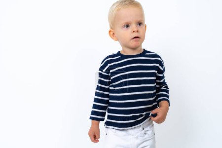 Téléchargez les photos : Studio portrait de beau garçon blond enfant portant col roulé rayé sur fond blanc - en image libre de droit