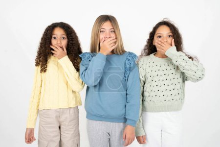 Téléchargez les photos : Émotionnel trois adolescentes halètements de l'étonnement, couvre la bouche ouverte avec la paume, semble choqué à la caméra. - en image libre de droit