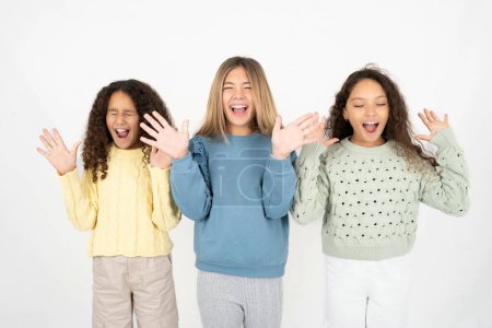 Téléchargez les photos : Emotive trois adolescentes rient bruyamment, entend une blague ou une histoire drôle, soulève les paumes avec satisfaction, - en image libre de droit