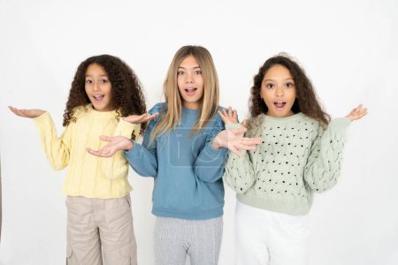 Foto de Tres chicas adolescentes celebrando loco y sorprendido por el éxito con los brazos levantados y los ojos abiertos gritando emocionados. Concepto ganador - Imagen libre de derechos