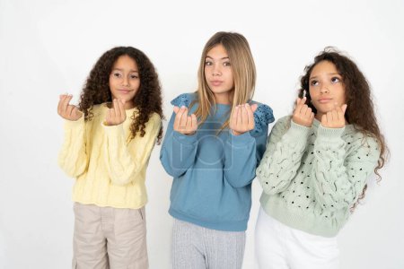 Foto de Tres chicas adolescentes haciendo gesto de dinero con las manos, pidiendo pago de sueldo, negocio millonario - Imagen libre de derechos