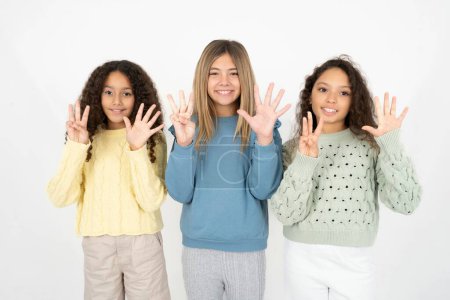 Photo for Three teenager girls showing and pointing up with fingers number eight while smiling confident and happy. - Royalty Free Image