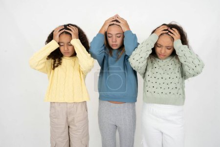 Foto de Tres adolescentes que sufren de dolor de cabeza fuerte desesperado y estresado debido al exceso de trabajo. Concepto de depresión y dolor. - Imagen libre de derechos