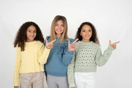 Foto de Tres chicas adolescentes apuntando hacia arriba con los dedos número ocho en chino lenguaje de signos B. - Imagen libre de derechos