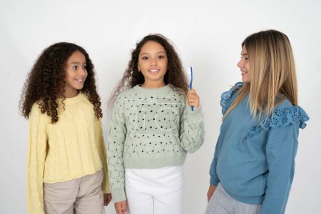Téléchargez les photos : Trois adolescentes tenant une brosse à dents et souriant. Concept de soins dentaires. - en image libre de droit