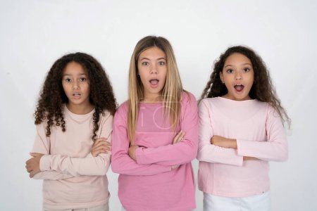 Photo for Shocked embarrassed three teenager girls keeps mouth widely opened. Hears unbelievable novelty stares in stupor - Royalty Free Image