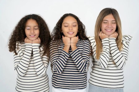 Foto de Alegre tres chicas adolescentes tiene expresión satisfecha tímida, sonríe ampliamente, muestra dientes blancos, emociones de la gente - Imagen libre de derechos