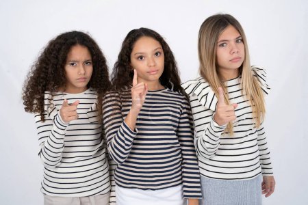 Foto de Tres chicas adolescentes frustradas y apuntando hacia el frente - Imagen libre de derechos