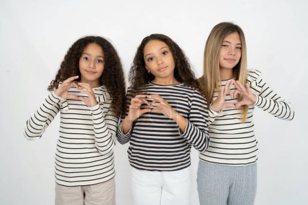 Photo for Serious three teenager girls keeps hands crossed stands in thoughtful pose concentrated somewhere - Royalty Free Image