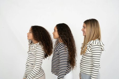 Téléchargez les photos : Profil portrait de belles trois adolescentes regardent espace vide sourire - en image libre de droit