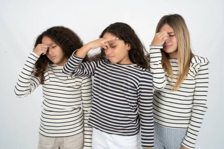 Téléchargez les photos : Triste trois adolescentes souffrant de maux de tête tenant la main sur son visage - en image libre de droit