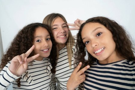 Foto de Positivo tres adolescente niñas tomar selfie hacer v-signo - Imagen libre de derechos