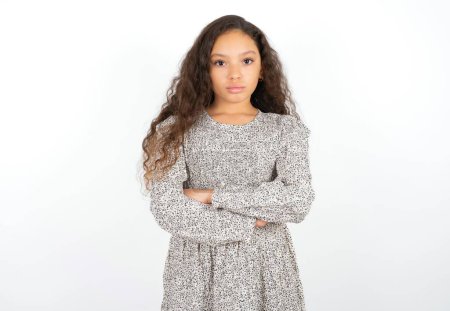 Foto de Serio pensativo adolescente chica usando gris vestido contra blanco fondo sentir como fresco seguro empresario cruz manos. - Imagen libre de derechos