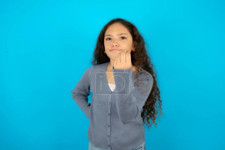 Photo for Teenager girl wearing grey sweater against blue background angry gesturing typical italian gesture with hand, looking to camera - Royalty Free Image