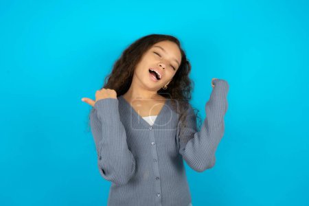 Ecstatic teenager girl wearing grey sweater shout loud yeah fist up raise win lottery