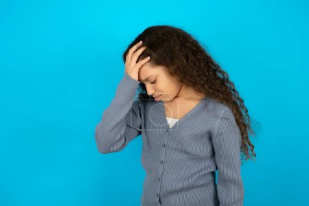 Téléchargez les photos : Une adolescente très bouleversée et solitaire portant un pull gris pleurant - en image libre de droit