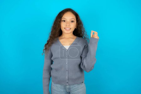 Photo for Teenager girl wearing grey sweater pointing up with hand showing up seven fingers gesture in Chinese sign language Q. - Royalty Free Image