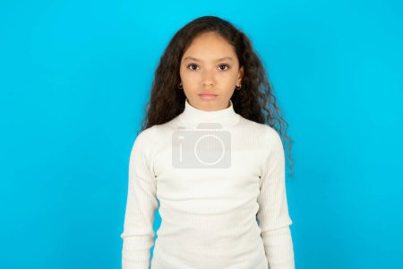 Offended dissatisfied teenager girl wearing white sweater with moody displeased expression at camera being disappointed by something