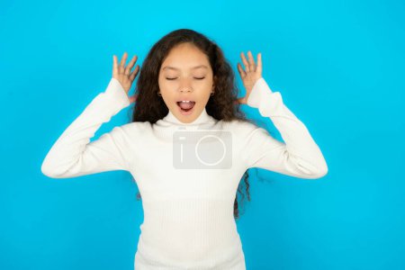 Photo for Teenager girl wearing white sweater goes crazy as head goes around feels stressed because of horrible situation - Royalty Free Image