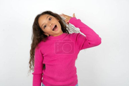Photo for Teenager girl wearing pink sweater foolishness around shoots in temple with fingers makes suicide gesture. Funny model makes finger gun pistol - Royalty Free Image