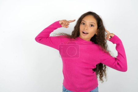 Foto de Alegre adolescente chica usando rosa suéter demostrando peinado - Imagen libre de derechos