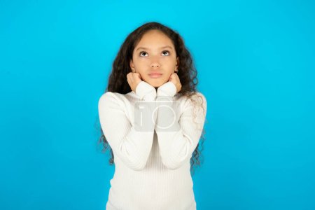 Photo for Portrait of sad teenager girl wearing white sweater hands face look empty space - Royalty Free Image