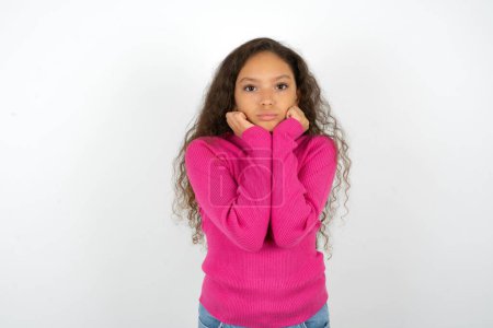 Photo for Portrait of sad teenager girl wearing pink sweater hands face - Royalty Free Image