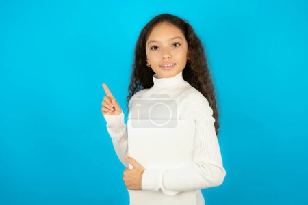 Foto de Adolescente chica usando blanco suéter celebración portátil mostrando copia de espacio vacío anuncio - Imagen libre de derechos