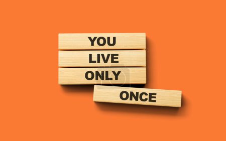 Téléchargez les photos : Vous ne vivez qu'une seule fois texte YOLO sur des blocs en bois isolés sur fond orange, illustration 3d - en image libre de droit