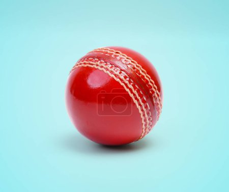 Eine glänzende neue Test Cricket Match Ball Leder hart genäht Ball Nahaufnahme Foto auf blauem Hintergrund
