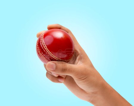 Männliche Bowler Griff zum leuchtend roten Test Cricket Ball Nahaufnahme Foto auf weichem blauen Hintergrund