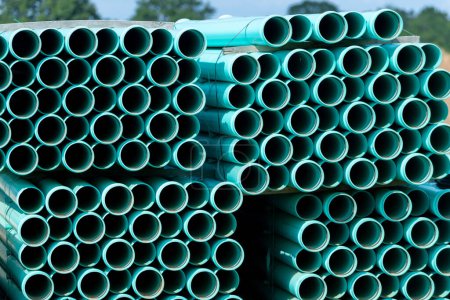 Foto de Un montón de tuberías verdes apiladas en un sitio de construcción suministro de drenaje nueva entrega - Imagen libre de derechos