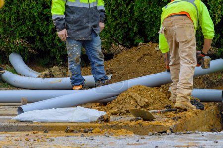 Foto de Laying and installation of a sewer pipe water ground man plastic - Imagen libre de derechos
