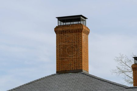 Foto de Brick ventilation pipe on the roof red top color - Imagen libre de derechos