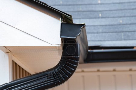Photo for Gutter with downpipe on the roof of a house rooftop - Royalty Free Image