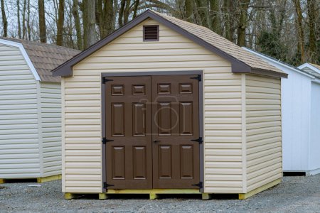 Téléchargez les photos : Cute small wooden storage shed, with windows and shingle roof new store gray - en image libre de droit