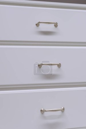 Foto de White kitchen cabinets with metal pulls or knobs on the doors close up modern handle room - Imagen libre de derechos
