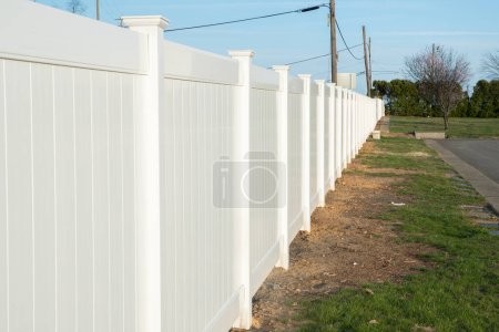 Photo for White vinyl fence in residential neighborhood home nature plastic new grass modern - Royalty Free Image