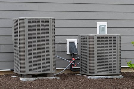 Foto de Unidad de sistema de aire acondicionado instalada fuera de la nueva casa enfriador de ventilador de control fresco - Imagen libre de derechos